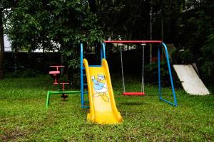 um parque infantil com um escorrega na relva em S RIVER RESORTS em Cochin