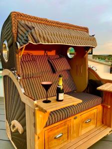 einen Stuhl mit einer Flasche Wein und einem Weinglas in der Unterkunft Penthouse am Südstrand - Dachterrasse mit Meerblick und Gasgrill, Klimaanlage, Luxus-Design-Apartment, 2 Minuten zum Strand, Strandkorb in Binz