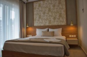 a bedroom with a large bed with a painting on the wall at Astra Sarti Luxury Suites in Sarti