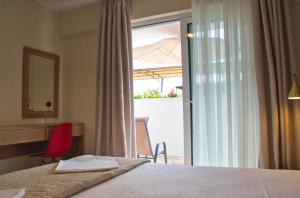 a hotel room with a bed and a sliding glass door at Astra Sarti Luxury Suites in Sarti