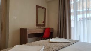 a hotel room with two beds and a desk with a mirror at Astra Sarti Luxury Suites in Sarti