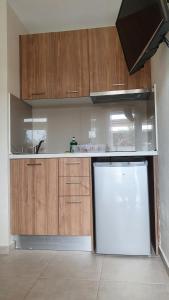 a kitchen with wooden cabinets and a white refrigerator at Astra Sarti Luxury Suites in Sarti