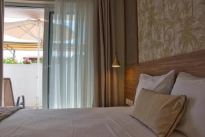 a bedroom with a white bed with a wooden headboard at Astra Sarti Luxury Suites in Sarti