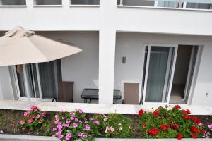 an umbrella and flowers in front of a building at Astra Sarti Luxury Suites in Sarti
