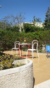 マリーナ・ディ・モーディカにあるCasa White Jasmineの椅子2脚、テーブル1台、テーブル1台、椅子1脚