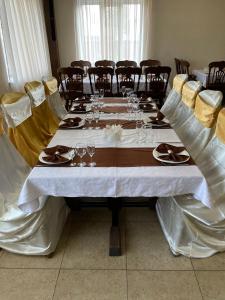 a long table with chairs and a white table cloth at Hotel Grant in Kharkiv