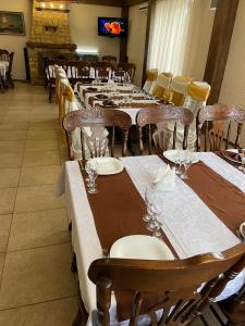 a dining room with tables and chairs and a tv at Hotel Grant in Kharkiv