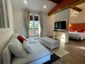 a living room with a white couch and a tv at L'Estirado des Adrets in Les Adrets de l'Esterel