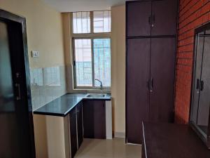 una cocina con fregadero y ventana en Fernandes Complex, en Bangalore