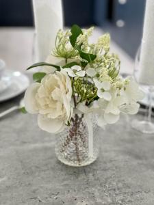 un jarrón lleno de flores blancas en una mesa en No 49 a spacious executive apartment in Inverness, en Inverness