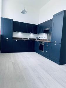 cocina con armarios azules y suelo blanco en No 49 a spacious executive apartment in Inverness, en Inverness