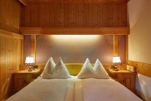 A bed or beds in a room at Landhaus Aamadall im Alpinresort Sport & Spa