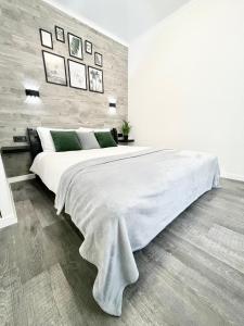 um quarto branco com uma grande cama branca com almofadas verdes em Элегантная квартира-студия ЖК Рич Таун, Ирпень em Irpin