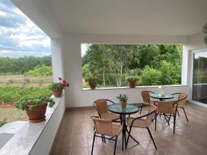 a balcony with a table and chairs and a window at Pansion Lazine in Međugorje
