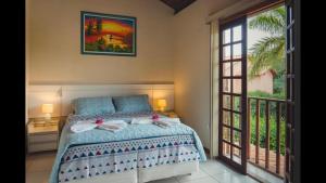 ein Schlafzimmer mit einem Bett und einem großen Fenster in der Unterkunft Casa Linda Lençóis, Chapada Diamantina, Bahia in Lençóis