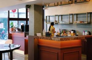 a woman standing at a counter in a kitchen at Golden House BTS Chidlom Bangkok in Bangkok