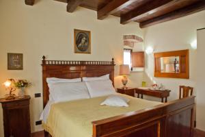 a bedroom with a large bed with a wooden headboard at Azienda Agrituristica Corteforte in Fumane