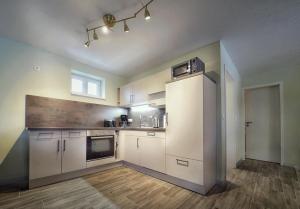 an empty kitchen with white cabinets and a window at Bungalow am Neustädter See in Neustadt-Glewe