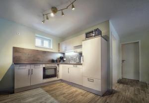 eine leere Küche mit weißen Schränken und einem Fenster in der Unterkunft Bungalow am Neustädter See in Neustadt-Glewe