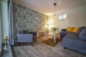 ein Wohnzimmer mit einer Couch und zwei Sesseln in der Unterkunft Bungalow am Neustädter See in Neustadt-Glewe