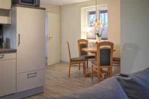 eine Küche und ein Esszimmer mit Tisch und Stühlen in der Unterkunft Bungalow am Neustädter See in Neustadt-Glewe