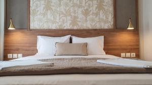 a bedroom with a large bed with white pillows at Astra Sarti Luxury Suites in Sarti