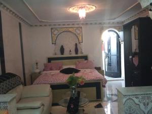 a bedroom with a bed and a couch and a table at Hôtel Marrakech in Tangier