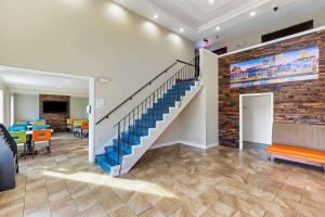 a lobby with a staircase and a brick wall at Days Inn by Wyndham Savannah Gateway I-95 in Savannah