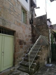 um edifício de pedra com uma porta e uma escada em Viela alojamentos Amarante em Amarante