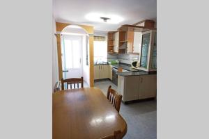 eine Küche und ein Esszimmer mit einem Holztisch in der Unterkunft Covas Playa Casita in Viveiro