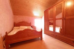 1 dormitorio con cama de madera y armario de madera en Covas Playa Casita, en Viveiro