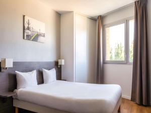 a hotel room with a bed and a window at Aparthotel Adagio Access Nogent sur Marne in Nogent-sur-Marne