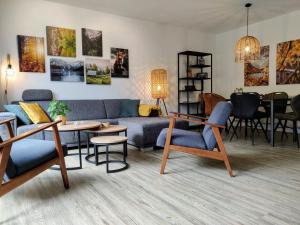 sala de estar con sofá azul y sillas en Elpe Apartments Hochsauerland, en Elpe