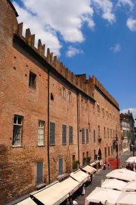 un grande edificio in mattoni con ombrelloni di fronte di Antico Residence a Mantova