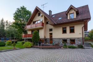 a large house with a patio in front of it at Penzión Javor - apartmány in Ždiar