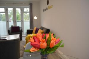 un jarrón de flores sobre una mesa en la sala de estar en Modern 1 Bed Apartment in Hatfield - Walking distance to Uni & Business Park - FREE Onsite Parking, en Hatfield