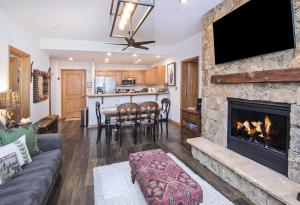 a living room with a fireplace and a table with chairs at Aspenwood #207 Condo in Edwards