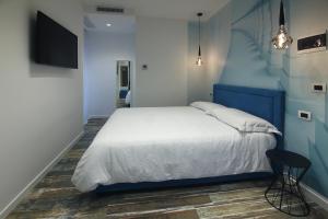 1 dormitorio con cama blanca y pared azul en Interno 7, en Bari