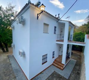 une maison blanche avec un escalier et un balcon. dans l'établissement Stay Wild en Las Casitas de Huerta Arriba, à Benamahoma