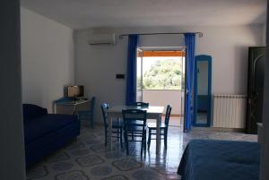 d'un salon avec une table, des chaises et une fenêtre. dans l'établissement Villa Myremi, à Ischia