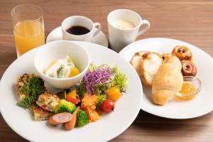 deux assiettes de nourriture sur une table avec du café et du pain dans l'établissement Hakodate Danshaku Club Hotel & Resorts, à Hakodate