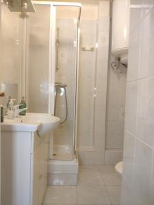 a white bathroom with a shower and a sink at Le noisy in Noisy-le-Sec +14 photos