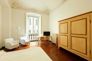 a bedroom with a large wooden door and a living room at Palazzo Cicala in Genoa +45 photos