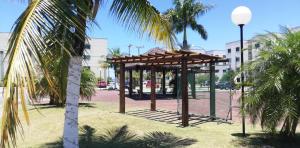a gazebo in a park with a palm tree at Residencial Marina Club in São Pedro da Aldeia