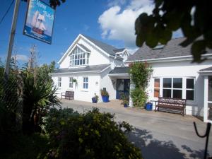 a white house with a bench in front of it at The Moorings B&B in Duncannon