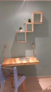a wooden desk with a laptop on a wall with shelves at Charmant studio à Sfax in Sfax