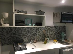 un bancone da cucina con lavello e microonde di Charmant studio à Sfax a Sfax
