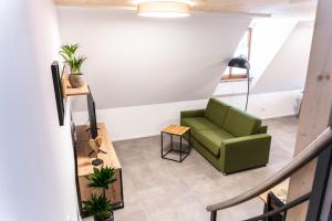 un salon avec une chaise verte et une table dans l'établissement 4 Apartments im Hof by Gasthof Linde, à Albstadt