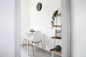 uma sala de jantar branca com uma mesa e cadeiras brancas em New & Modern Apartment with Beautiful Lake View! em Lugano