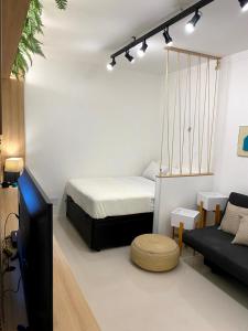 サントスにあるStudio moderno na avenida da praia - Boqueirãoのベッドとテレビとソファのある部屋